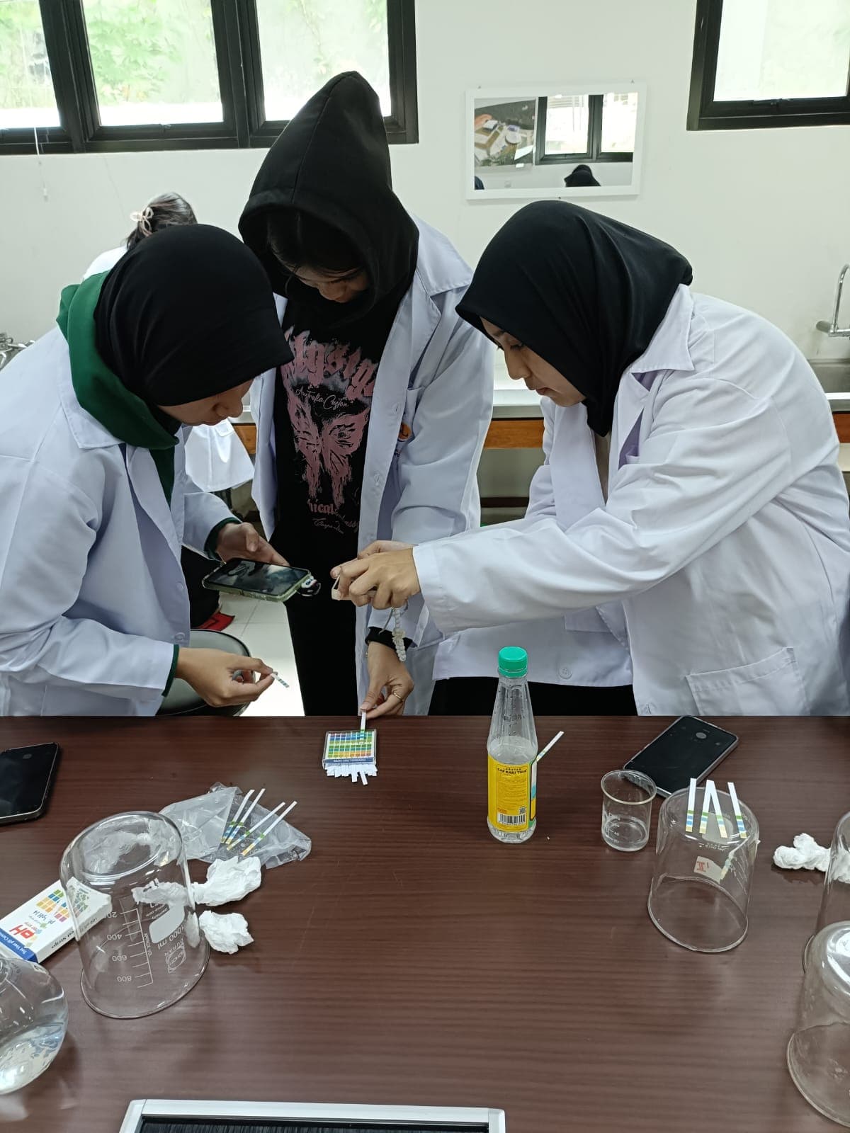 Mahasiswa Teknik Lingkungan STT PU Jakarta melakukan pengujian parameter kualitas air menggunakan indikator pH universal di laboratorium